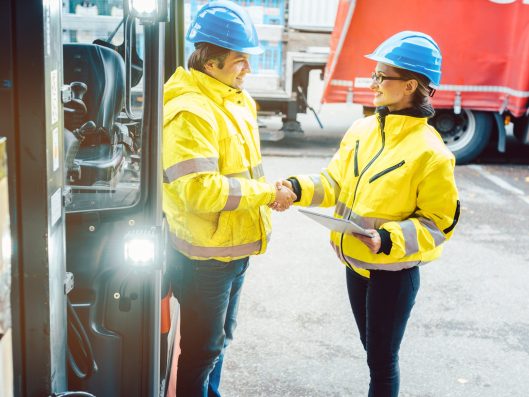 Worker and manager shaking hands at distribution center
