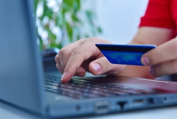 Close up of man using a credit card and purchasing products onli